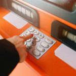 Donna inserisce il PIN all'ATM